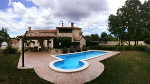 A house with a swimming pool, a patio, and a garden.
