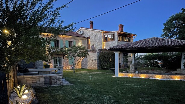 A stone house with a patio and outdoor lighting.