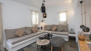 A modern living room with a sectional sofa, a round coffee table, and a small side table.