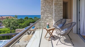 A balcony with stone walls, two wicker chairs, a small wooden table, and a view of the sea. - Stunning  villa for 6 people with private pool, WIFI, A/C, TV, terrace and pets allowed (Umag)