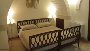 Ein Schlafzimmer mit einem Bett, zwei Nachttischlampen, einem Holz-Kopfteil und einer gewölbten Decke.