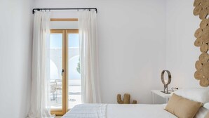 A bedroom with a bed, a bedside table with a mirror, and a view of the outdoors through a glass door. - SODA Y LIMÓN - Amazing sea and mountain views, private (heated) pool, air conditioning (Sayalonga)