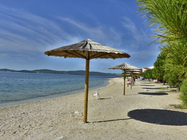 A beach with umbrellas and a clear view of the sea.