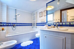 Un baño con bañera, lavamanos e inodoro.
