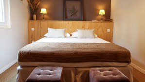 A bedroom with a wooden headboard, two bedside lamps, a star decoration, and a bed with a brown quilt.
