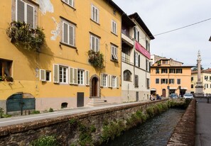 Ein Gebäude am Kanal mit mehreren Fenstern und einer Steinmauer.