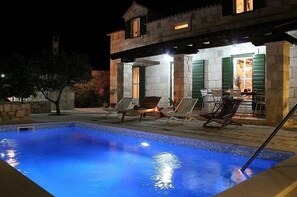 Relax by the pool surrounded by a stone deck and lounge chairs.