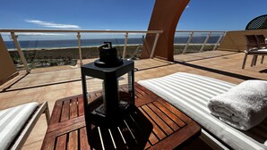 Uma varanda com uma mesa de madeira, um aquecedor preto e uma toalha branca.