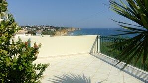 Un balcón con vistas al mar y casas al fondo.