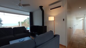 Een moderne woonkamer met een bank, televisie en een lamp.