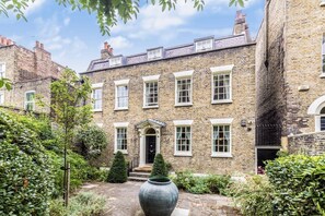 Traditional architecture with a central entrance and lush courtyard.