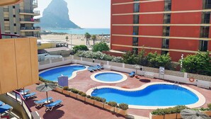 A hotel with a rooftop pool area, including sun loungers and a view of the beach and a mountain. - Cosy apartment for 2 people with A/C, WIFI, pool, TV and terrace (Calpe)