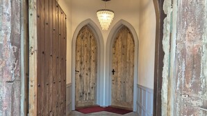 A hallway with wooden doors, a red carpet, and a chandelier. - No.2 The Old Convent (Fort Augustus)