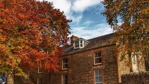 A stone building with a traditional design, featuring multiple windows and a prominent entrance. - No.2 The Old Convent (Fort Augustus)