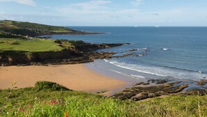 A coastal landscape with a sandy beach, rocky shoreline, and grassy hills. - Luxury Lodge, South Devon Coast nr Plymouth, 200m to Beach + Indoor Heated Pool, (Nr Plymouth)