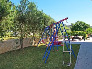 A playground with a swing set and climbing structure.