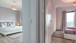 Ein modernes Schlafzimmer mit Bett, Kleiderschrank und Blick ins Freie.