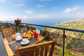 A table with breakfast items and a view of the sea. - Casa das Abertas, Jacuzzi, Sea View & A/C (Arco da Calheta)