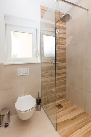 Tina con regadera, secadora de cabello, bidet, toallas 