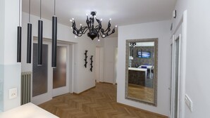 A modern interior with a herringbone wood floor, a black chandelier, and a large mirror on the wall. - Vila Marija - perfect vacation apartment (Ljubljana)