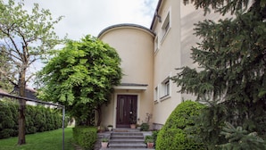 A building with a curved facade, a dark entrance door, and a small set of stone steps leading up to it. - Vila Marija - perfect vacation apartment (Ljubljana)