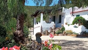 A garden with blooming roses and a white building with a red roof. - The Casetta di Merau Sant'Antioco (Sant'Antioco)