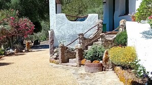 A stone pathway leading to a white building with a covered entrance and stone columns. - The Casetta di Merau Sant'Antioco (Sant'Antioco)