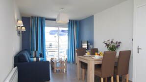 Uma sala de estar moderna com sofá e um espaço de refeições com mesa e cadeiras.