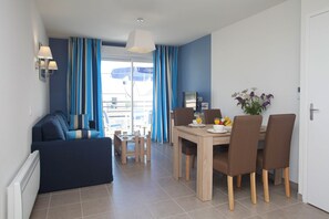 Ein modernes Wohnzimmer mit einer Couch und einem Essbereich mit Tisch und Stühlen.