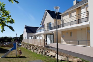 A residential building with a balcony, a play area, and a street lamp.