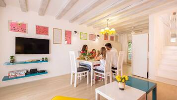 Relax in this stylish living room with a flat-screen TV, dining area, and comfortable seating.