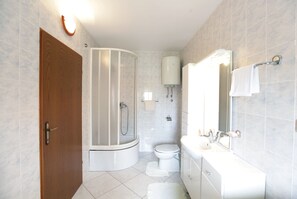 Een bad/douchecombinatie, een haardroger, handdoeken, shampoo