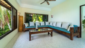 A modern living room with a sectional sofa, a coffee table, and a ceiling fan. - White Azure (Ko Pha-ngan)