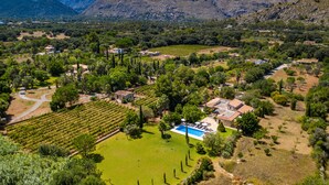 An aerial view of a property with a swimming pool, vineyard, and mountainous backdrop. - Entertainment-packed, Spacious, Peaceful & Convenient (Pollença)