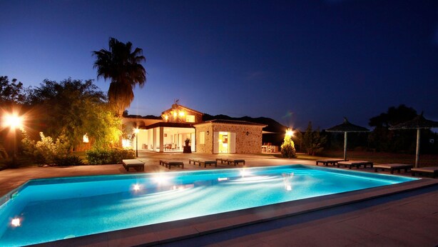 A swimming pool with lounge chairs and a building with outdoor seating. - Entertainment-packed, Spacious, Peaceful & Convenient (Pollença)