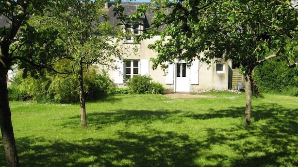 A house with a front yard, surrounded by trees and greenery. - House with garden (Plobannalec-Lesconil)