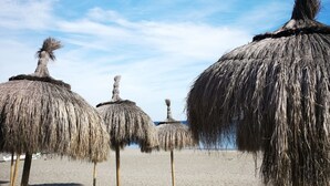 A beach with thatched umbrellas and a clear blue sky. - Beach Diamond - fantastic duplex right on the beach close to everything (Marina de Casares)
