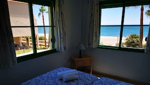 A room with a bed, a nightstand, and a view of the beach. - Beach Diamond - fantastic duplex right on the beach close to everything (Marina de Casares)