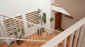 A staircase with white railings, a wooden door, and potted plants.