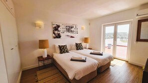 A hotel room with two beds, a balcony, and a cityscape view. - Villa Bela Vista T3 +1 (Lagos)