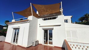 A two-story building with a white exterior, large windows, and a covered patio area. - Villa Bela Vista T3 +1 (Lagos)