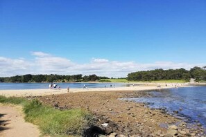 A beach with a rocky shoreline, a sandy area, and a clear blue sky. - Apartment in Bretagne near Morbihan Coast (BADEN)