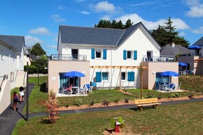 A residential building with a covered patio area, outdoor seating, and a small garden. - Apartment in Bretagne near Morbihan Coast (BADEN)