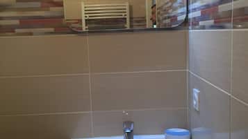 Een haardroger, handdoeken, zeep, toiletpapier