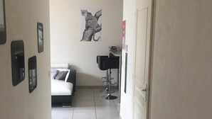 Un pasillo estrecho con una cama, un escritorio y una obra de arte con estampado de leopardo en la pared.