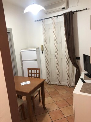 Cozy retreat with a wooden table, refrigerator, and television for a comfortable stay.
