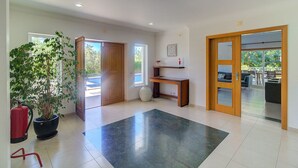 A spacious room with a large potted plant, a wooden desk, and a view of the outdoors through a glass door. - Villa Marazul Quinta Amizade w/ Sea View, Games room, Salt pool (Guia)