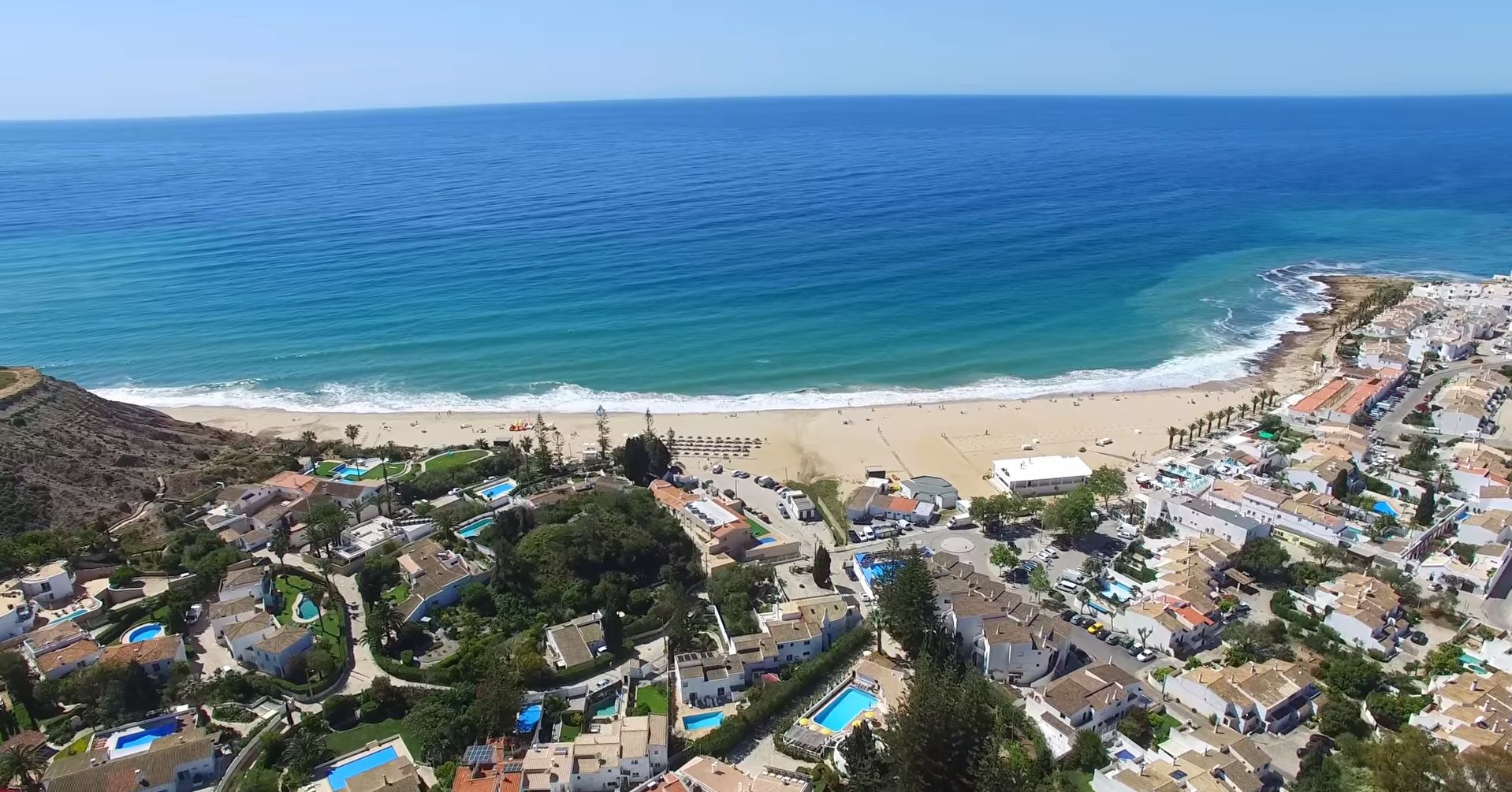 Praia da Luz, con playa, zona residencial y piscinas.