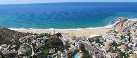 Praia da Luz, con playa, zona residencial y piscinas.
