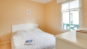 Una camera da letto con un letto, un comodino, una finestra vista e una luce a soffitto.